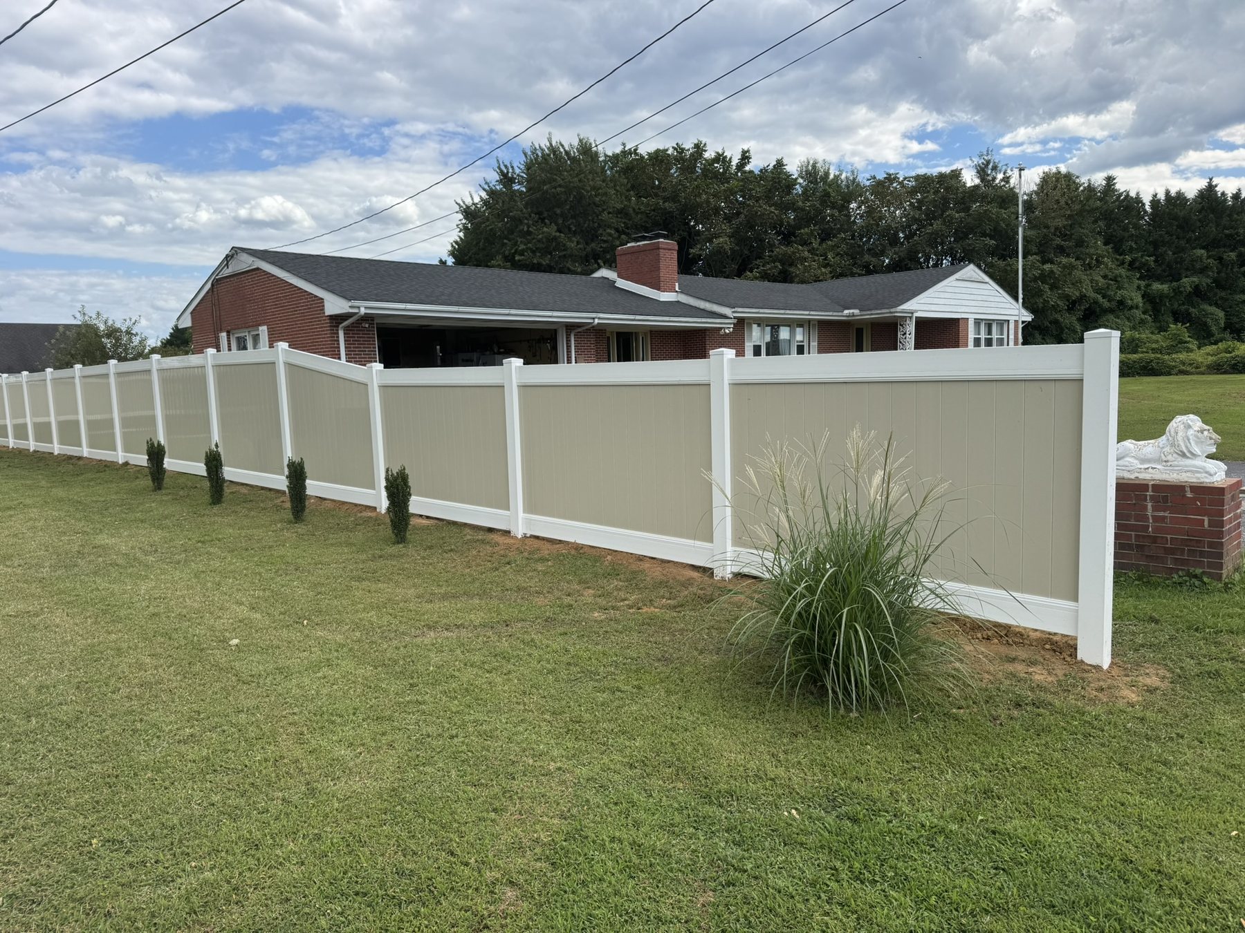 Two-tone vinyl privacy fence with tan panels and white posts along a Kent County property