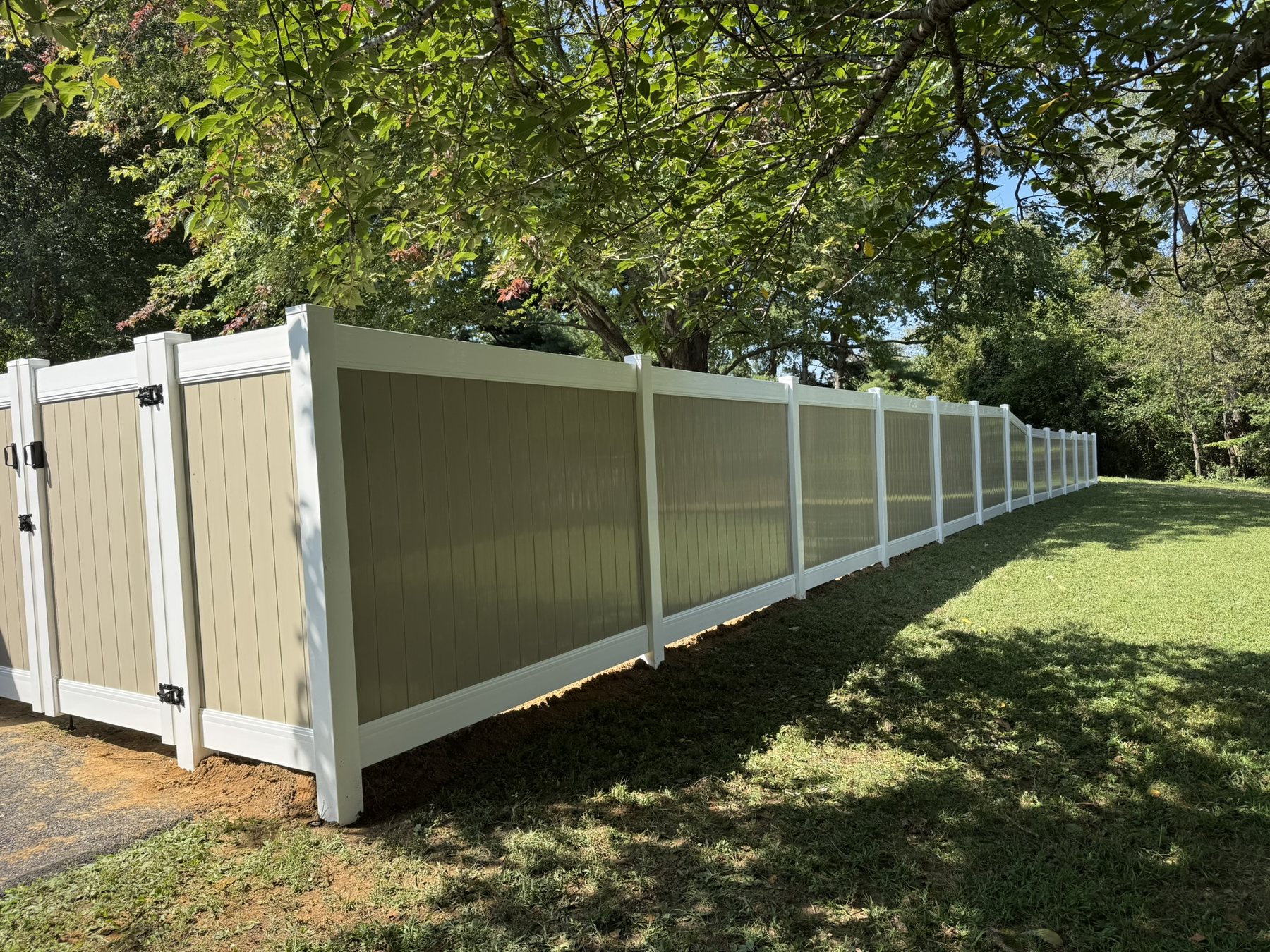 Two-tone vinyl privacy fence with khaki panels, white posts, rails, and a walk gate