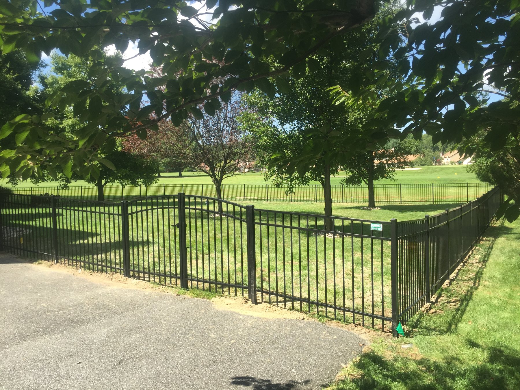 Black aluminum double gate across a residential driveway