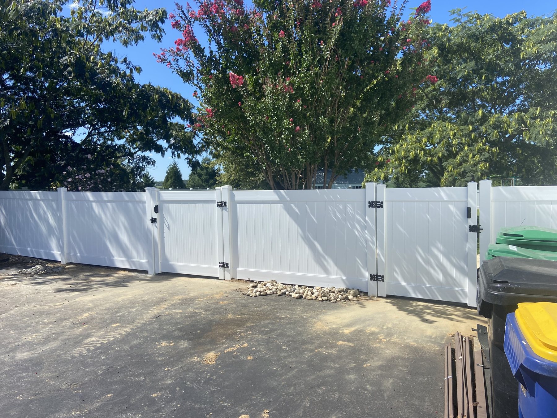 White vinyl privacy double gate opening to a backyard